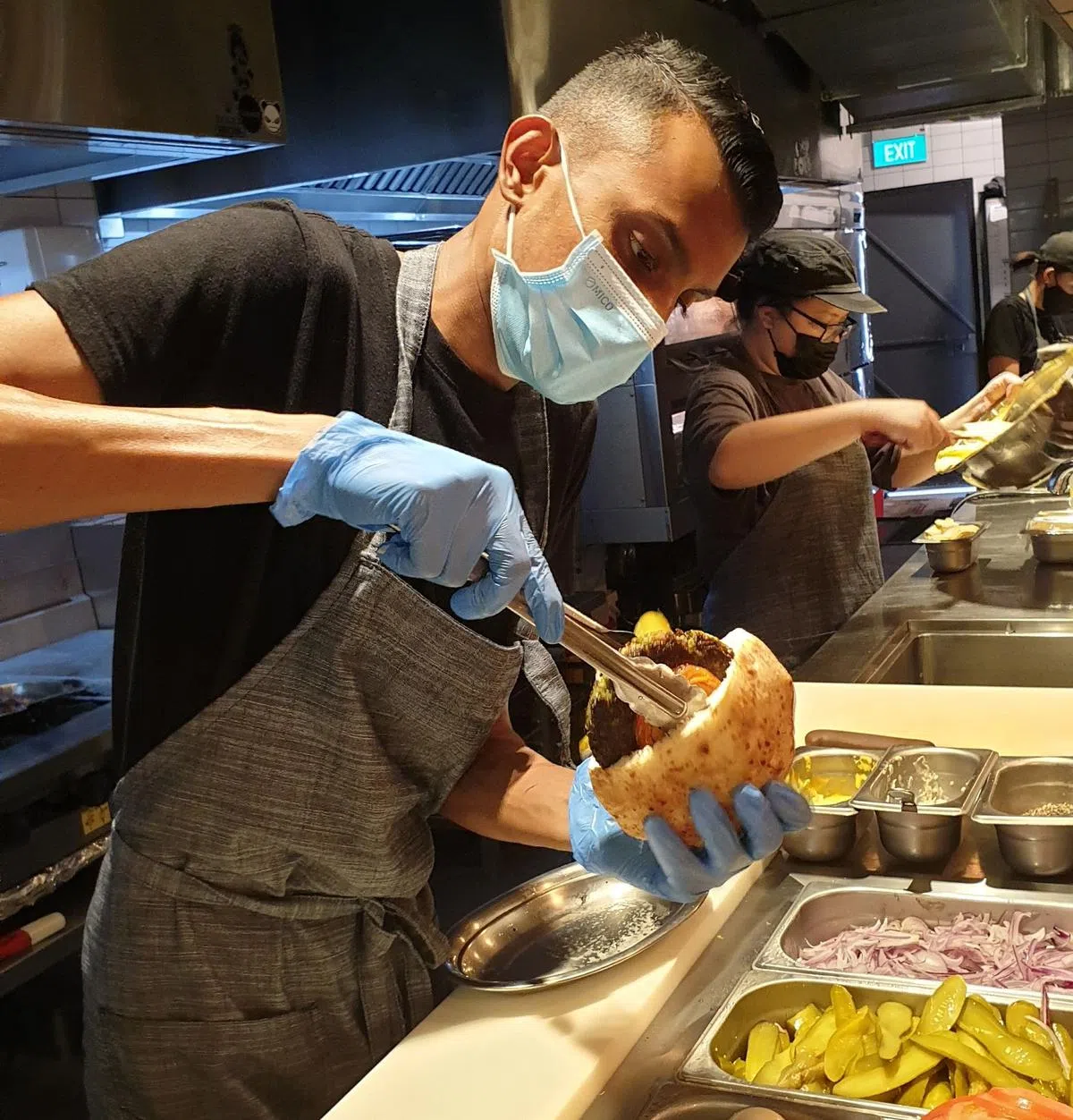 餐馆店员将各类馅料放入以色列口袋饼。