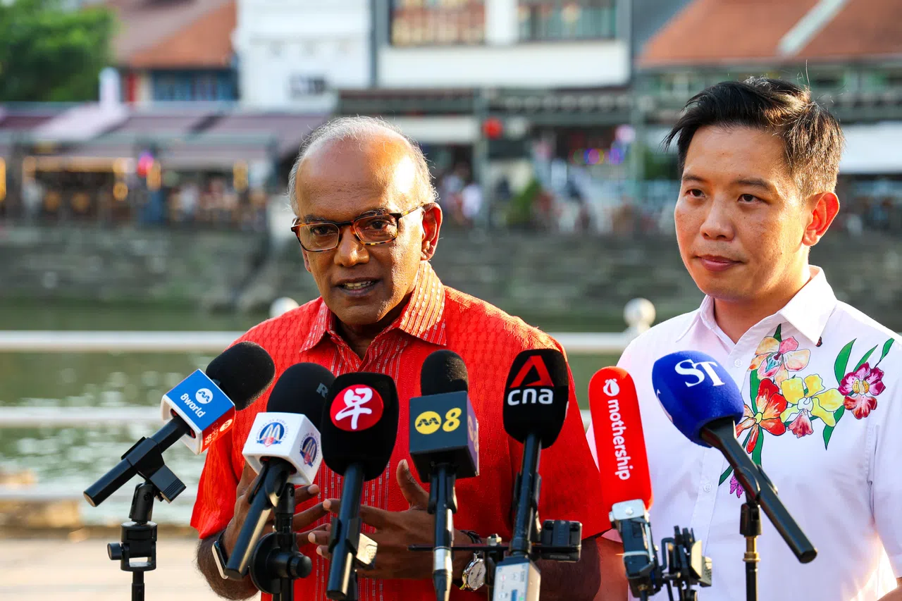国家安全统筹部长兼内政部长尚穆根（左）和贸工部兼国家发展部政务部长陈圣辉（右），星期四（8月7日）在新加坡河畔回答媒体询问。（林明顺摄）