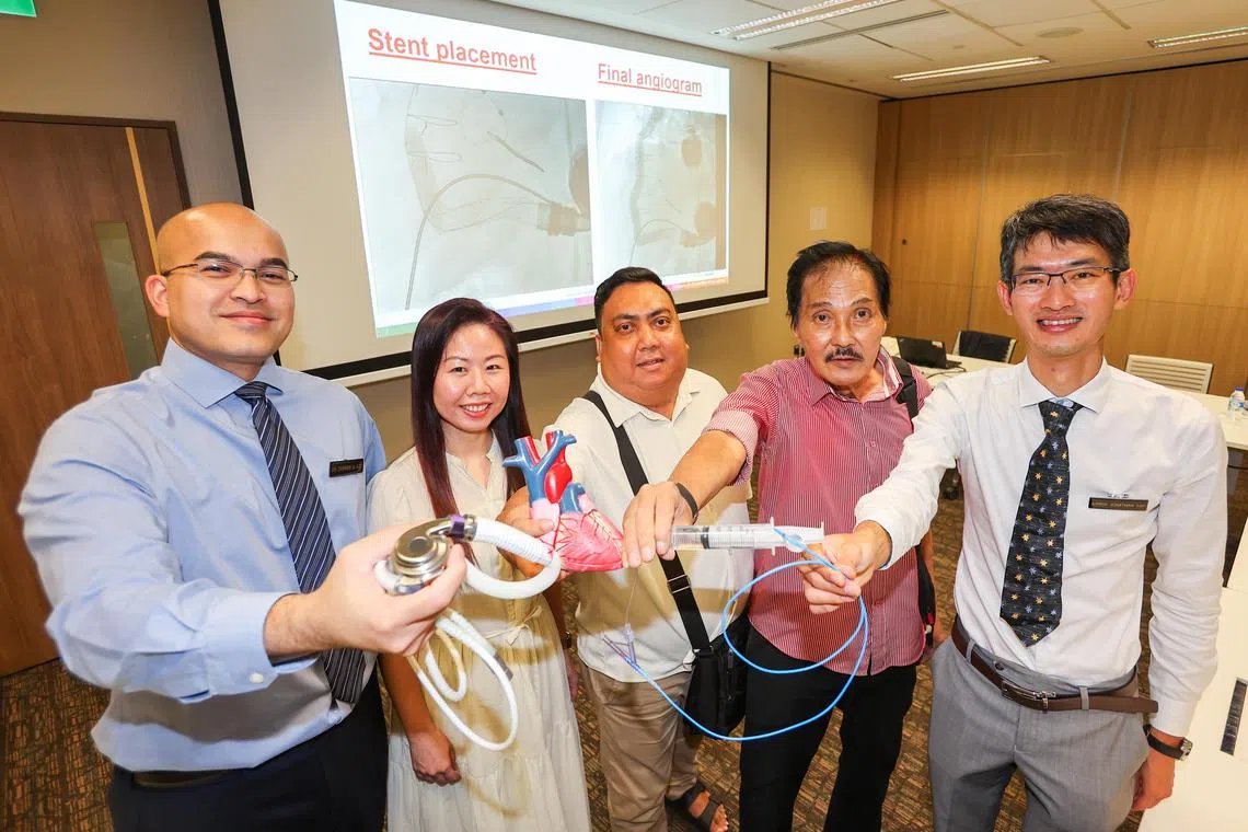 新加坡国家心脏中心结构性心脏介入治疗主任叶俊良副教授（右一），心胸外科顾问医生查希尔（Zameer Abdul Aziz） 助理教授（左一），主要临床协调员郑慧敏（左二）和接受过“机械心脏泵”修复手术的患者黄俊贤（右二）和里萨尔（Rizal Ismal，中）,　星期四在记者会上共同接受记者采访。（陈斌勤摄）