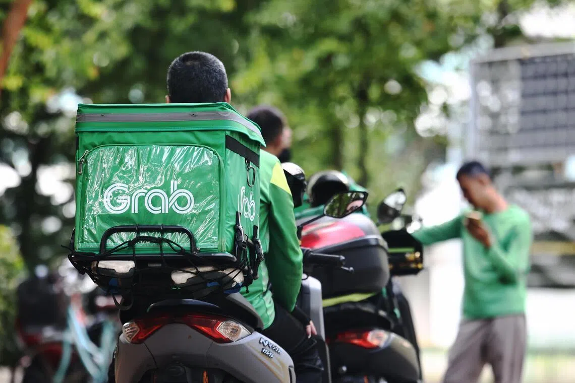 随着燃油价格因中东冲突上涨，平台人员首当其冲，有议员建议政府提供补贴以减轻负担。图为路边等候订单的Grab送餐员。（档案照片）