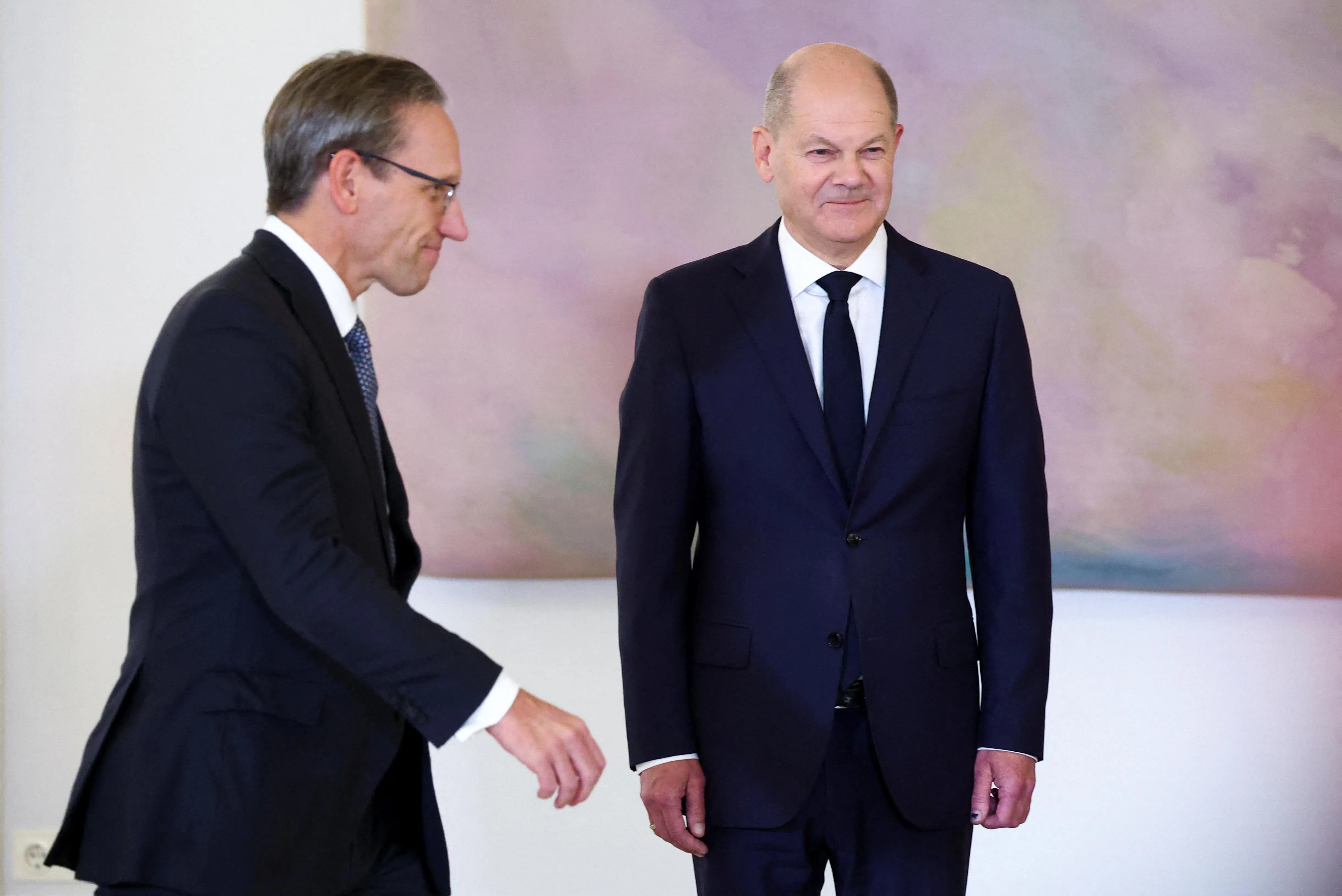 新任德国财政部长库基斯（左）走过总理朔尔茨（右）面对，准备从德国总统施泰因迈尔手里接过委任状。（路透社）