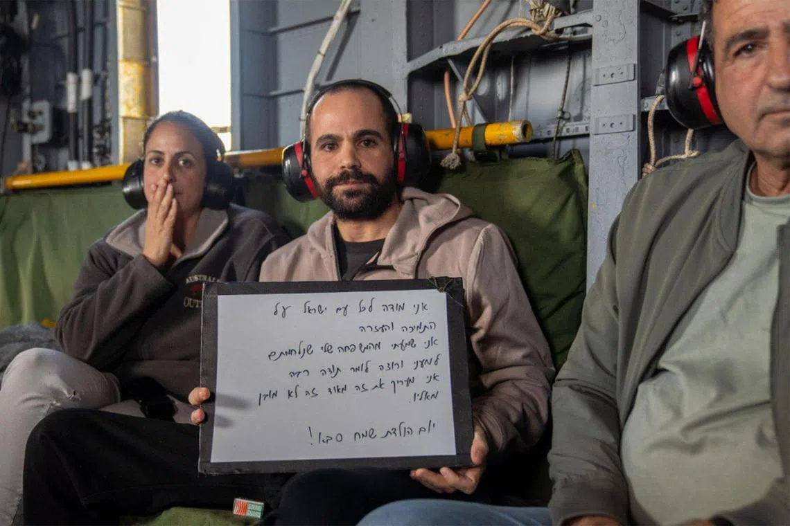 以色列人质雅尔登·比巴斯（中）获释后，在父亲和姐姐的陪同下乘坐军用直升机前往医院。（法新社）