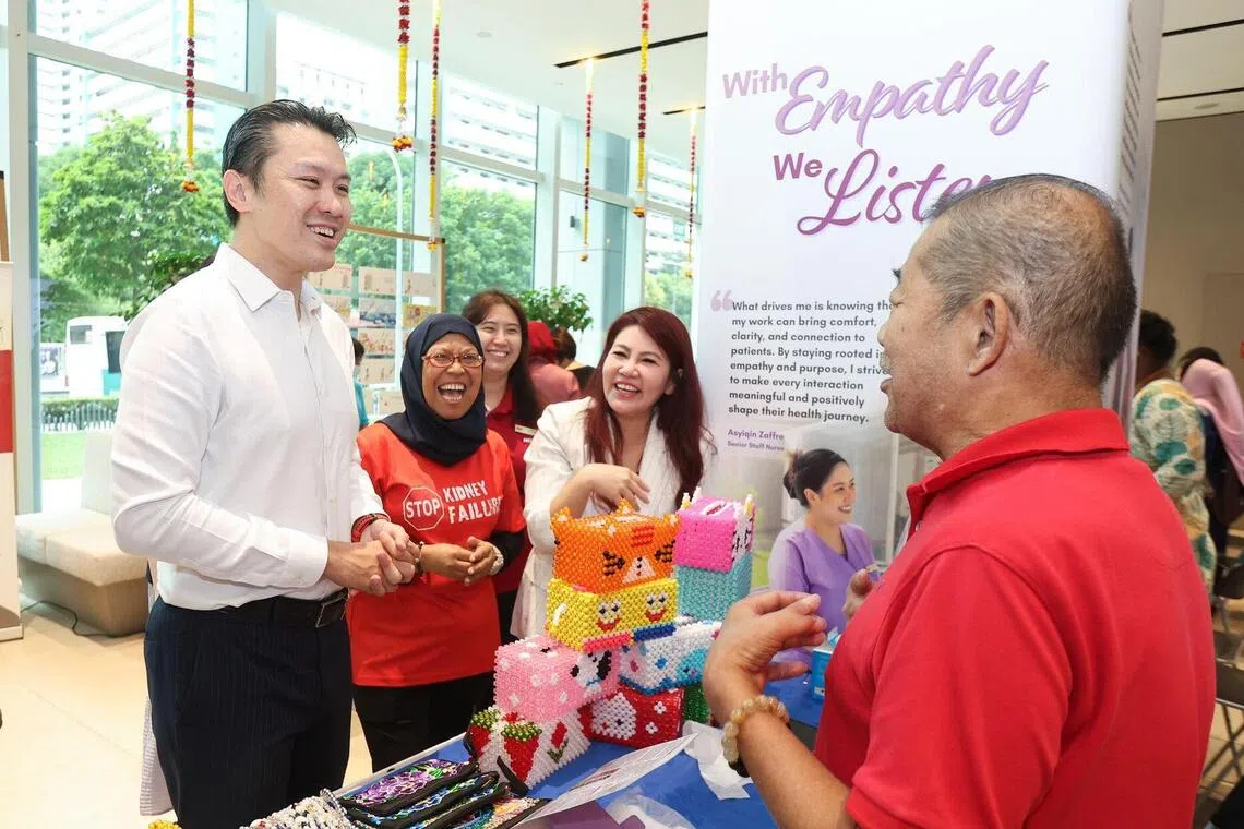 财政部兼人力部高级政务次长黄伟中（左一）与在职业展设摊卖手工艺品的洗肾患者交流。（全国肾脏基金会提供）