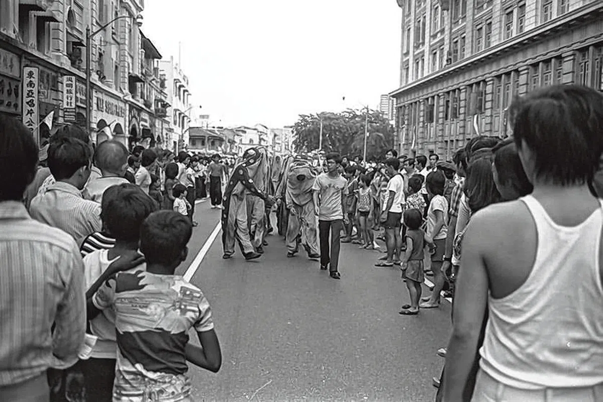 1975年的禧街。当时人们就倚在住家窗口看国庆游行，图右为禧街警察局，左边的屋子已被夷为平地。