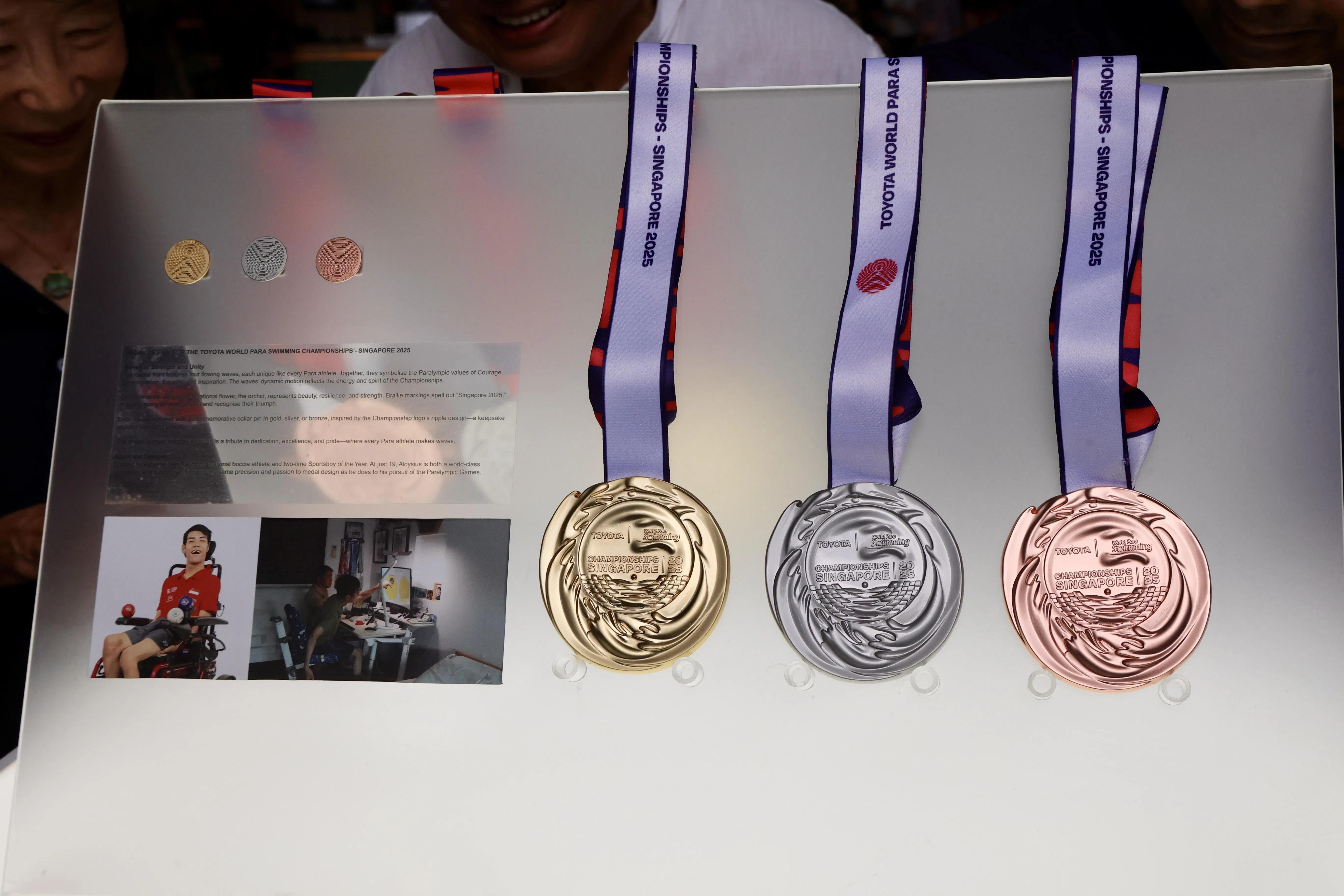 由我国选手颜恺宏设计的奖牌结合了四种波浪图案，以及新加坡国花胡姬花。（邝启聪摄）