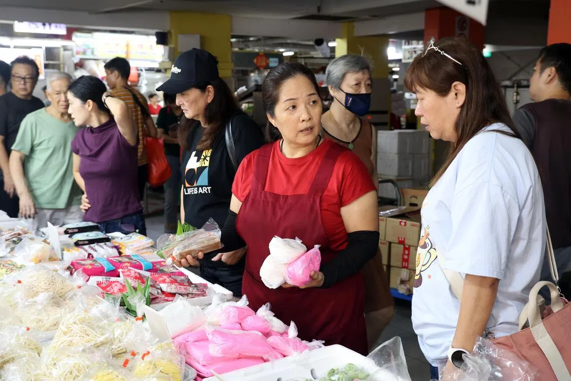 除了售卖糯米团，沈亚玉（穿围裙者）还会热心地向顾客详细讲解包汤圆和煮汤圆的细节。（邝启聪摄）
