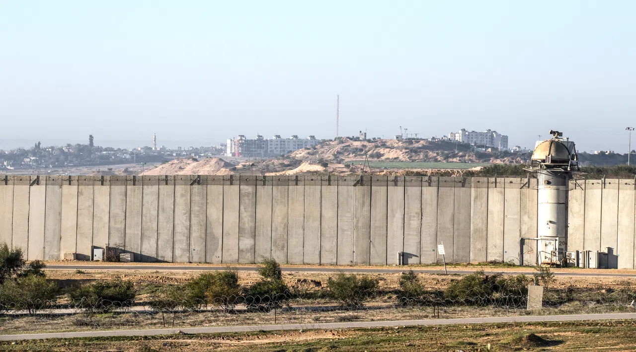以色列—加沙边界，摄于2017年2月7日。高墙屏障的这一边是以色列，围墙背后是巴勒斯坦民宅大楼。（法新社）