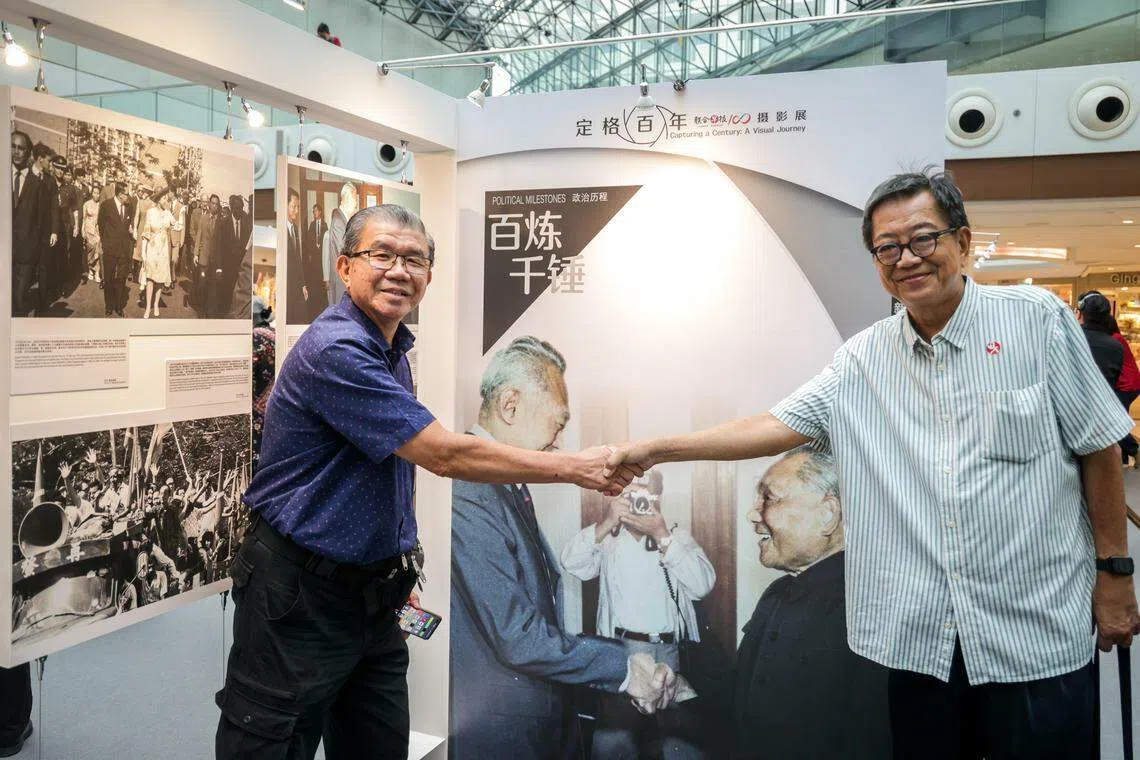 《联合早报》举办的“定格百年”摄影展。1988年9月17日，时任总理李光耀在北京人民大会堂与当时的中国军委主席邓小平会面，随行记者包括《联合早报》前总编辑林任君（右）和退休摄影记者熊俊华。两人在摄影展看到这张照片，回忆起当时的采访情况。（档案照片）