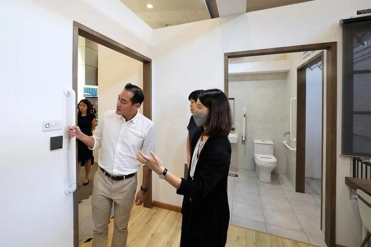 国家发展部兼通讯及新闻部高级政务部长陈杰豪（中）星期四（10月27日）参观位于建屋局中心的展览，了解将在下月推出的女皇镇社区关爱组屋设施。（李冠卫摄）