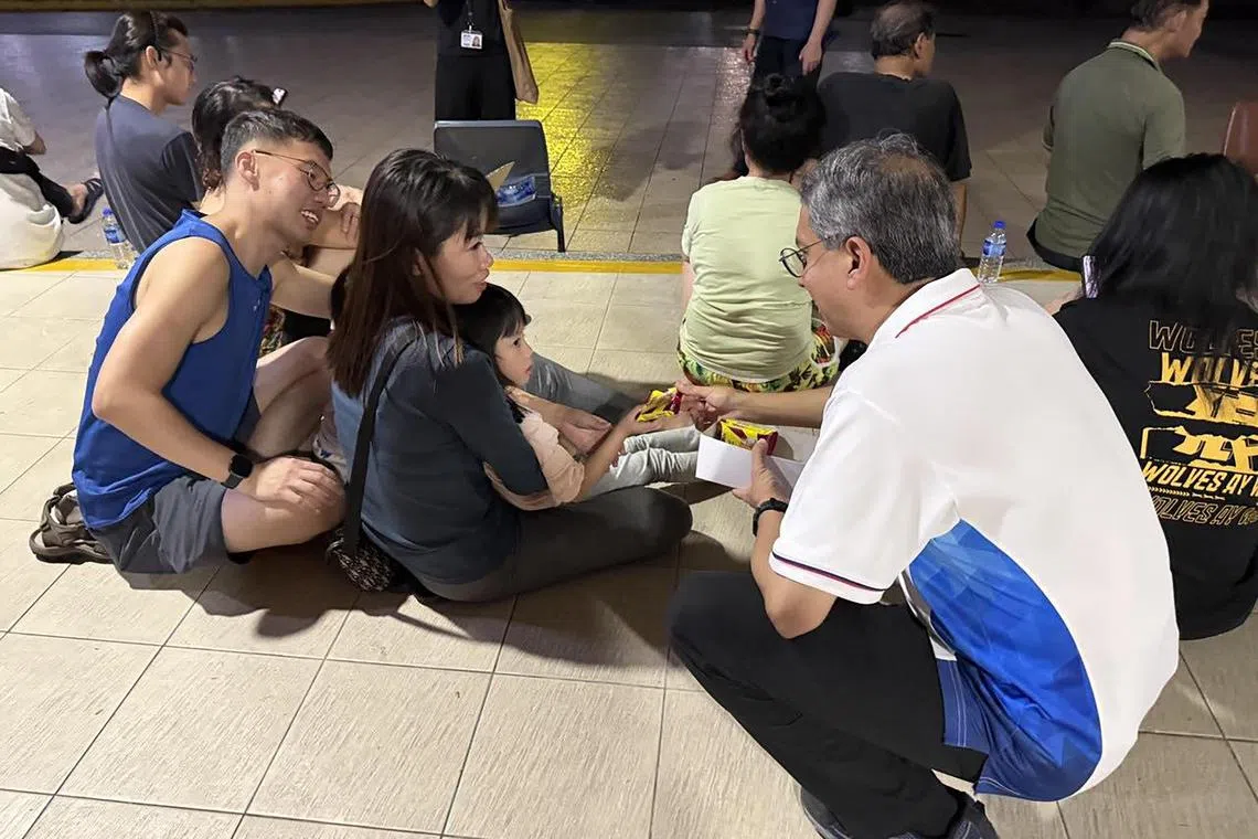 费绍尔副教授（右一）分饮用水及饼干给疏散至楼下的居民。（取自费绍尔脸书）