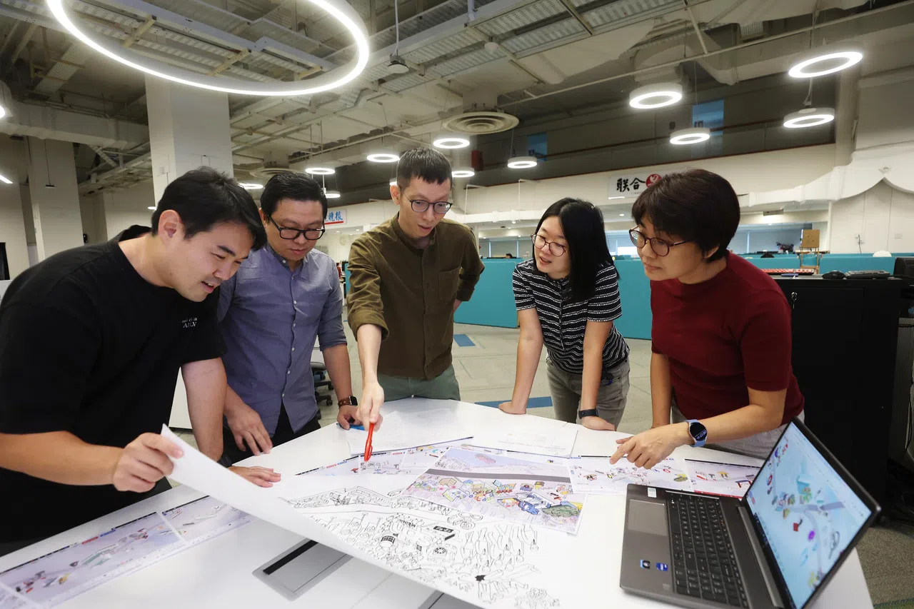 百年浩荡化为具体图像跃然于《世纪早报》长卷，是《联合早报》视觉部和近50人长卷团队的心血结晶。看着长卷从2023年2月出炉的最早有具体图像的草图，到最后化为数码平台上的多媒体互动长卷，两位主要设计师陈聪明（左二，视觉部主任）与卢芳楷（左三，视觉部高级美术员）兴奋地向部分团队成员展现成果。右二是《世纪百年》长卷统筹王舒杨（影音群组主任），长卷历史小组成员兼视频监制林琬绯（右一）及视频创意组长刘永健（左一） 。（蔡家增）