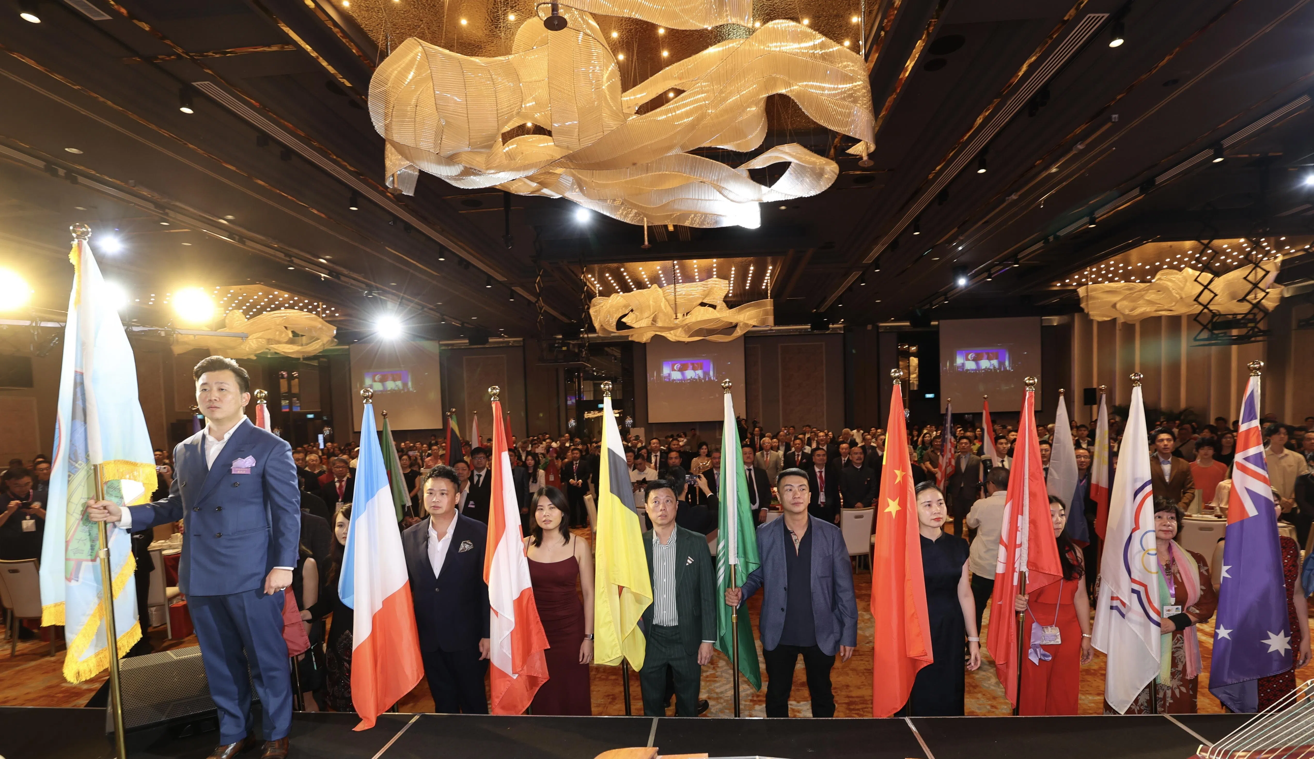 世惠会晚宴开场由世界各地区惠州乡亲代表，在举旗人的带领下进入会场。（邬福梁摄）
