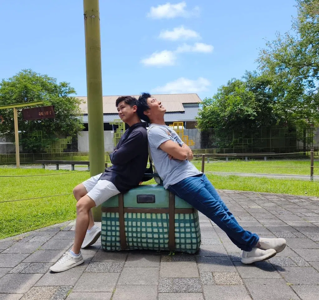 和陈熙坐在旅行箱上拍照，陈之财说这张照片颇有“人生旅途”的意境。（陈之财提供）